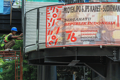 Pekerja menyelesaikan pembangunan Jembatan Penyebrangan Sepeda sekaligus JPO di Jalan Sudirman, Karet Tengsin, Jakarta Pusat, Sabtu (28/8/2021).