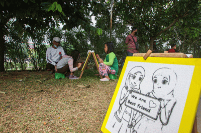 Seorang anak menunjukan hasil karya mewarnai miliknya di kawasan Banjir Kanal Timur, Jakarta, Minggu (29/8/2021).