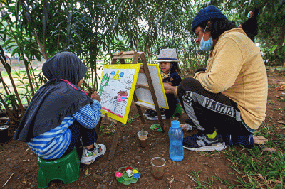 Seorang anak menunjukan hasil karya mewarnai miliknya di kawasan Banjir Kanal Timur, Jakarta, Minggu (29/8/2021).