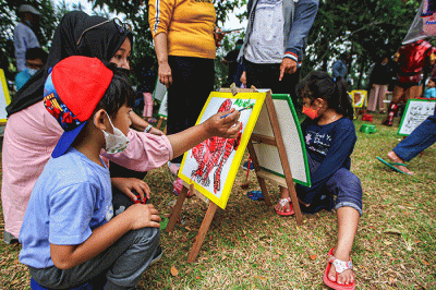 Seorang anak menunjukan hasil karya mewarnai miliknya di kawasan Banjir Kanal Timur, Jakarta, Minggu (29/8/2021).