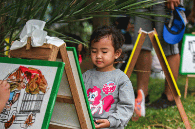 Seorang anak menunjukan hasil karya mewarnai miliknya di kawasan Banjir Kanal Timur, Jakarta, Minggu (29/8/2021).