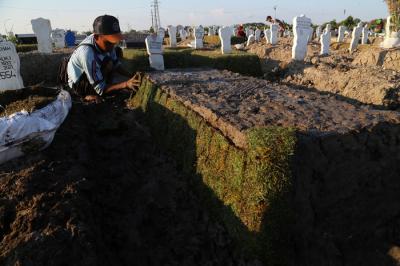 Pekerja melakukan perawatan makam khusus Covid-19 di TPU Keputih Surabaya, Jawa Timur, Rabu (1/9/2021).