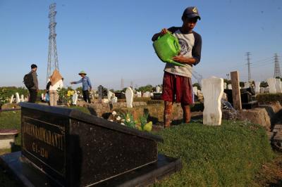 Pekerja melakukan perawatan makam khusus Covid-19 di TPU Keputih Surabaya, Jawa Timur, Rabu (1/9/2021).