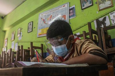 Seorang Guru menerangkan materi pembelajaran kepada murid secara tatap muka terbatas di SDN Semper Barat 01 Pagi, Jakarta, Rabu (1/9/2021).
