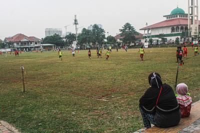 Warga terlihat sedang menghabiskan waktu sore di Lapangan Hawai Beji, Beji Timur, Kota Depok, Jawa Barat, Kamis (2/9/2021).