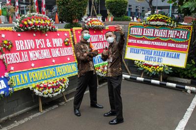 Warga berjalan di dekat karangan bunga di area parkir Gedung DPRD DKI Jakarta, Kebon Sirih, Jakarta Pusat, Jumat (3/9/2021).