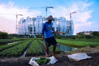 Petani merawat sayuran yang ditanam di lahan garapan dekat proyek pembangunan Jakarta International Stadium (JIS), Jakarta Utara, Senin (6/9/2021).