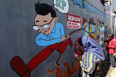 Mahasiswa Universitas Muhammadiyah Surabaya yang tergabung dalam Himpunan Mahasiswa Perbankan Syariah membuat mural edukasi di Surabaya, Senin (6/9/2021).