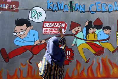 Mahasiswa Universitas Muhammadiyah Surabaya yang tergabung dalam Himpunan Mahasiswa Perbankan Syariah membuat mural edukasi di Surabaya, Senin (6/9/2021).
