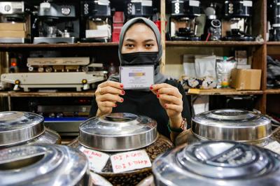 Pedagang menjaga toko sembakonya yang dipasang stiker sertifikat vaksin Covid-19 di Pasar Santa, Jakarta Selatan, Senin (6/9/2021).
