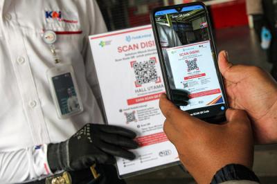 Calon penumpang memindai kode batang dari aplikasi PeduliLindungi sebelum melakukan perjalanan di Stasiun Manggarai, Jakarta, Selasa (7/9/2021).