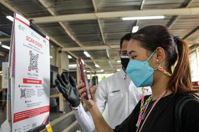 Calon penumpang memindai kode batang dari aplikasi PeduliLindungi sebelum melakukan perjalanan di Stasiun Manggarai, Jakarta, Selasa (7/9/2021).