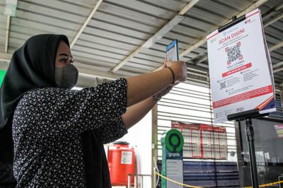 Calon penumpang memindai kode batang dari aplikasi PeduliLindungi sebelum melakukan perjalanan di Stasiun Manggarai, Jakarta, Selasa (7/9/2021).