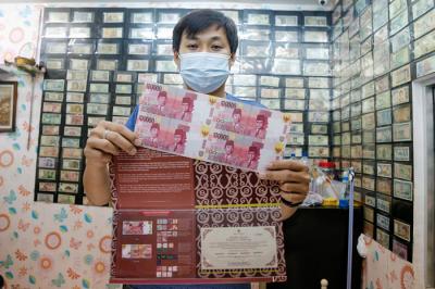Seorang penjual uang kuno, David menunjukkan uang kuno koin Rp2 perak tahun 1945 di tokonya di kawasan pertokoan Pasar Baru, Jakarta Pusat, Sabtu (11/9/2021).