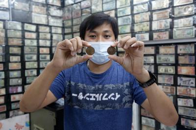 Seorang penjual uang kuno, David menunjukkan uang kuno koin Rp2 perak tahun 1945 di tokonya di kawasan pertokoan Pasar Baru, Jakarta Pusat, Sabtu (11/9/2021).