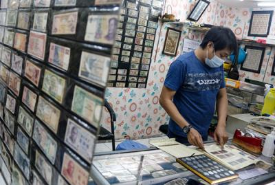 Seorang penjual uang kuno, David menunjukkan uang kuno koin Rp2 perak tahun 1945 di tokonya di kawasan pertokoan Pasar Baru, Jakarta Pusat, Sabtu (11/9/2021).