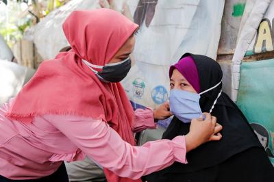 Relawan saat membagikan masker dan sosialiasasi pentingnya protokol kesehatan di Pela Mampang, Jakarta Selatan, Senin (13/9/2021).