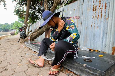 Warga saat memancing menggunakan alat pancing yang sudah dimodifikasi dengan jaring di Setu Pedongkelan, Depok, Jawa Barat, Minggu (12/9/2021).