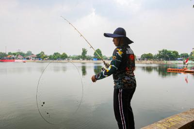 Warga saat memancing menggunakan alat pancing yang sudah dimodifikasi dengan jaring di Setu Pedongkelan, Depok, Jawa Barat, Minggu (12/9/2021).