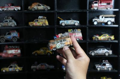 Perajin miniatur mobil, Adi Pradana Angga Nandyta, menyelesaikan pesanan miniatur mobil atau diecast di rumahnya di Surabaya, Jawa Timur, Senin (13/9/2021).