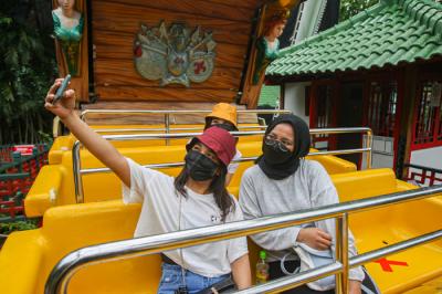 Pengunjung berswafoto di wahana permainan Dunia Fantasi, Ancol, Jakarta Utara, Selasa (14/9/2021).
