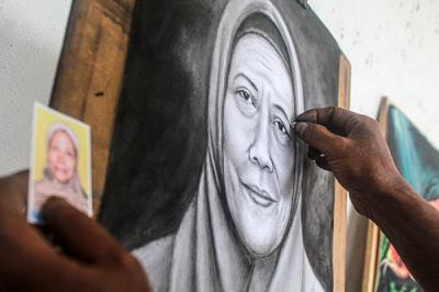 Seorang pelukis jalanan sedang menggambar potret wajah pelanggan di lorong kawasan Kota Tua, Jakarta Barat, Rabu (15/9/2021).