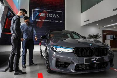 Business Consultant BMW menawarkan BMW M5 Competition kepada pengunjung usai peluncurannya di Jakarta, Jumat (17/9/2021).