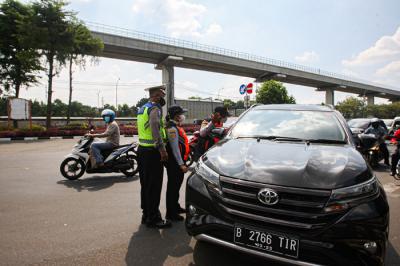 Petugas polisi dan dishub berjaga di depan Pintu 1 TMII, Jakarta Timur, Jumat (17/9/2021).
