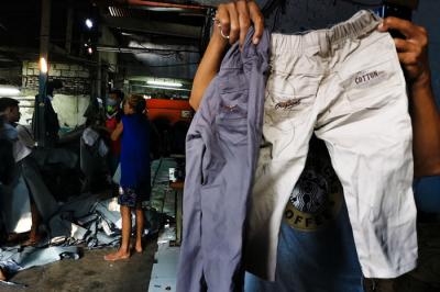 Pekerja sedang menyelesaikan pencucian celana garmen dan konveksi di kawasan Jakarta Barat, Jumat (17/9/2021).