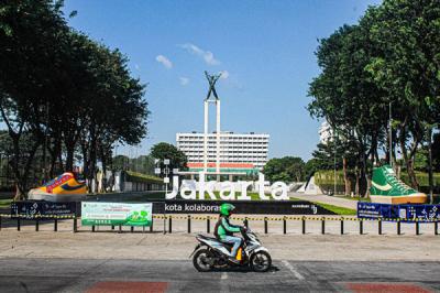 Warga melintasi dua tugu sepatu di Taman Lapangan Banteng, Jakarta Pusat, Jumat (17/9/2021).