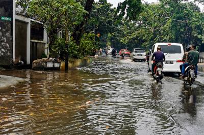Kendaraan saat melintasi genangan air di jalan raya Kebayoran Lama, Jakarta Selatan, Minggu (19/9/2021).