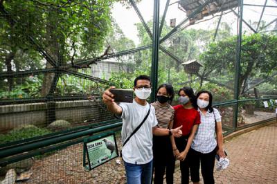 Pengunjung berswafoto di Taman Burung, Taman Mini Indonesia Indah (TMII), Jakarta Timur, Minggu (19/9/2021).