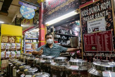 Suradi (42) pemilik Toko Dunia Kopi berpose di kiosnya di Pasar Santa, Jakarta Selatan, Senin (20/9/2021).