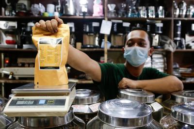 Suradi (42) pemilik Toko Dunia Kopi berpose di kiosnya di Pasar Santa, Jakarta Selatan, Senin (20/9/2021).