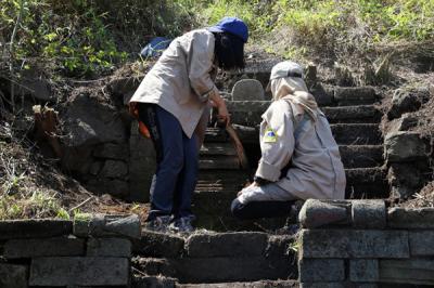 Tim Ekspedisi Ubaya membersihkan tanah dan pepohonan yang menutupi situs purbakala ketika melakukan ekspedisi di Gunung Penanggungan, Minggu (19/9/2021).