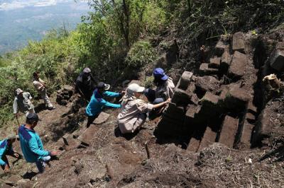 Tim Ekspedisi Ubaya membersihkan tanah dan pepohonan yang menutupi situs purbakala ketika melakukan ekspedisi di Gunung Penanggungan, Minggu (19/9/2021).
