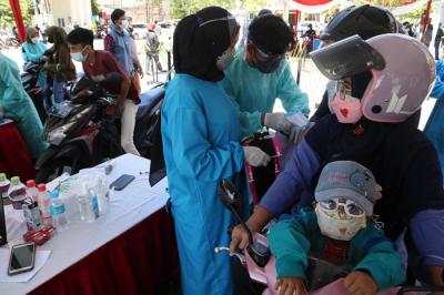 Warga mendapatkan suntikan vaksin Covid-19 ketika mengkuti vaksinasi dengan model Layanan Tanpa Turun (Lantatur) di UMSurabaya, Senin (20/9/2021).
