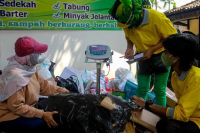 Warga mengumpulkan sampah yang akan dikonversi ke dalam buku tabungan di kawasan Jakarta Selatan, Selasa (21/9/2021).