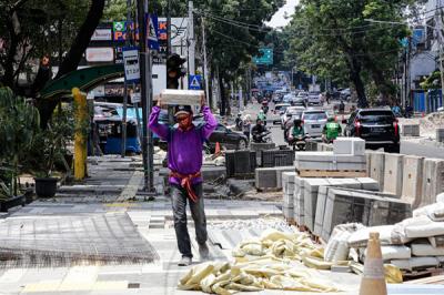 Pekerja menyelesaikan proyek revitalisasi trotoar di Jalan Senopati, Jakarta Selatan, Jumat (24/9/2021).