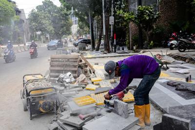 Pekerja menyelesaikan proyek revitalisasi trotoar di Jalan Senopati, Jakarta Selatan, Jumat (24/9/2021).