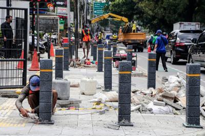 Pekerja menyelesaikan proyek revitalisasi trotoar di Jalan Senopati, Jakarta Selatan, Jumat (24/9/2021).