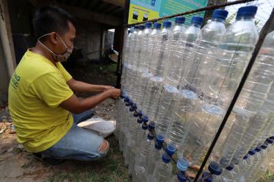 Warga merakit botol bekas menjadi tempat sampah di kawasan Situ Gintung, Tangerang Selatan, Banten, Sabtu (25/9/2021).