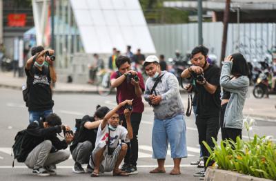 Sejumlah warga berfoto di kawasan Dukuh Atas, Jakarta, Minggu (26/9/2021).