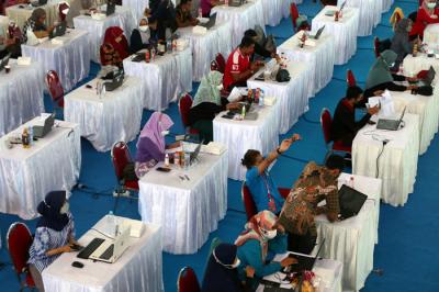 Petugas entry data peserta vaksin melakukan senam tangan untuk melenturkan ketegangan ketika menjalankan tugas di Surabaya, Jawa Timur, Kamis (30/9/2021).