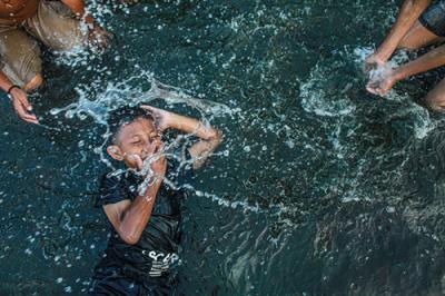 Sejumlah anak-anak sedang berenang riang di kawasan yang tergenang air laut di Dermaga Kali Adem, Jakarta Utara, Kamis (30/9/2021).