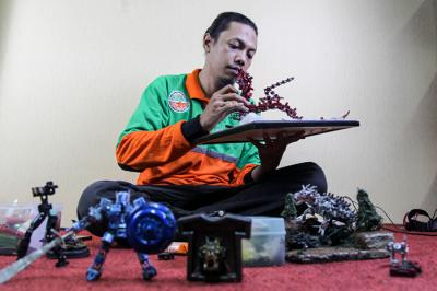 Seto Krisna Putra saat membuat miniatur robot dari limbah korek gas di Kantor Suku Dinas Lingkungan Hidup Jakarta Timur, Jumat (1/10/2021).