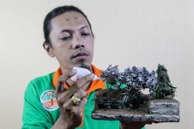 Seto Krisna Putra saat membuat miniatur robot dari limbah korek gas di Kantor Suku Dinas Lingkungan Hidup Jakarta Timur, Jumat (1/10/2021).