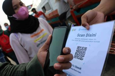 Calon penumpang menscan aplikasi PeduliLindung saat akan menaiki jasa transpotasi laut dan kapal cepat di Pelabuhan Kali Adem, Jakarta, Sabtu (2/10/2021).