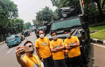 Sejumlah pengendara terlihat berswafoto di depan kendaraan taktis di kawasan Istana Merdeka, Jakarta Pusat, Senin (4/10/2021).