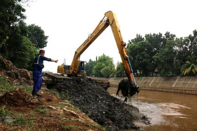 Petugas Dinas SDA Provinsi DKI Jakarta menggunakan alat berat saat mengeruk lumpur di aliran sungai Ciliwung, kampung Melayu, Jakarta, Senin (4/10/2021).
